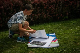 YOUNG FAN SORTING HIS AUTOGRAPHS